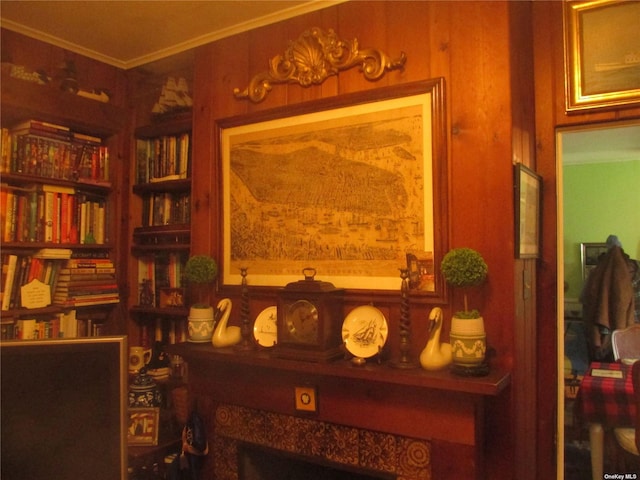 living area with ornamental molding and wood walls