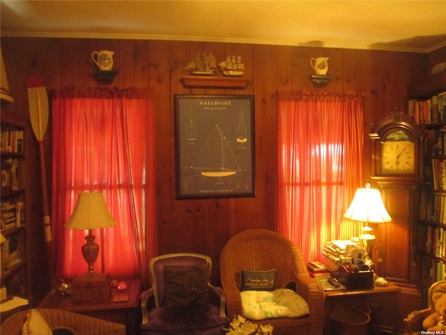 living area with wood walls and ornamental molding