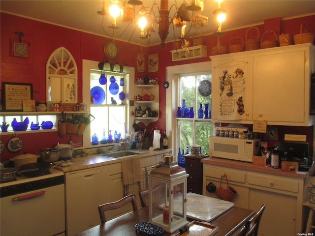 kitchen featuring sink, hanging light fixtures, an inviting chandelier, and a healthy amount of sunlight