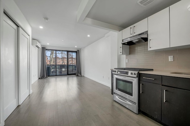 kitchen with stainless steel stove, white cabinetry, backsplash, hardwood / wood-style floors, and a wall mounted AC