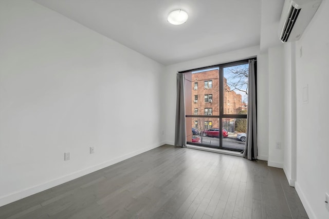 unfurnished room featuring wood-type flooring and an AC wall unit