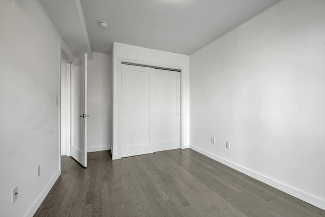 unfurnished bedroom featuring dark hardwood / wood-style floors and a closet