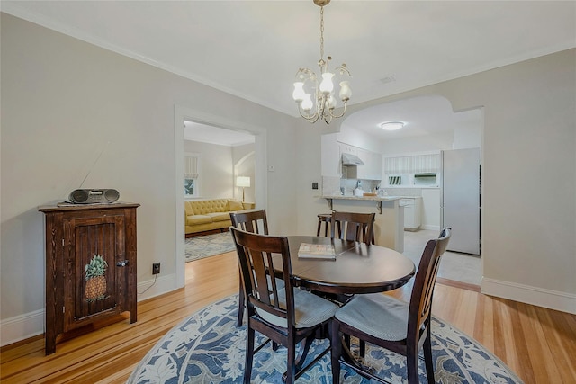 dining room featuring light wood-type flooring and an inviting chandelier