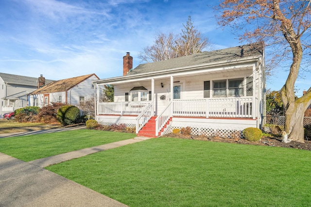 view of front facade with a front yard and covered porch