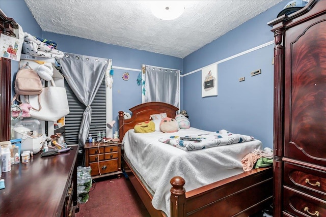 bedroom with dark carpet and a textured ceiling