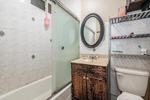 full bathroom with toilet, vanity, decorative backsplash, and shower / bath combination with glass door