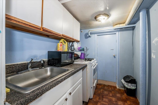 kitchen featuring dark parquet flooring, white range with gas stovetop, white cabinets, and sink