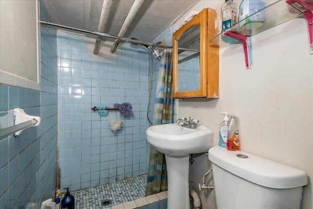 bathroom featuring toilet, a shower with shower curtain, tile walls, and sink