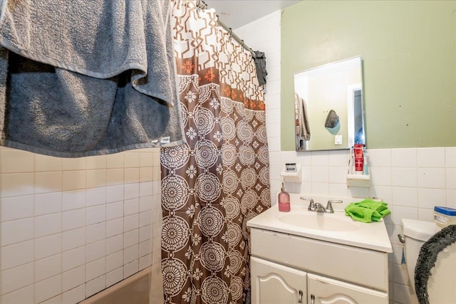 bathroom with tile walls, toilet, and vanity