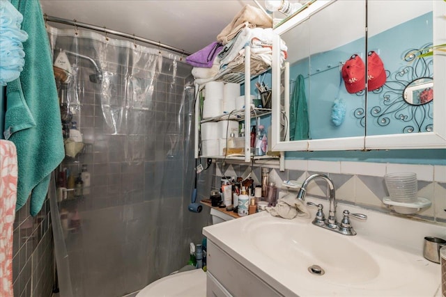 bathroom featuring toilet, vanity, tasteful backsplash, and curtained shower