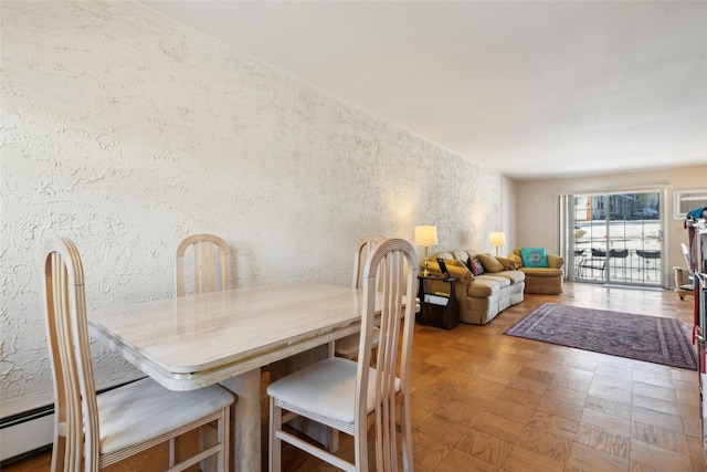 dining area with parquet floors and a baseboard heating unit