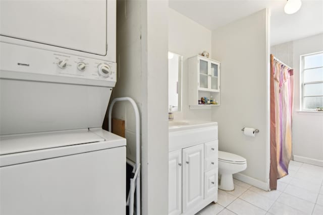 laundry room with light tile patterned floors and stacked washer / dryer