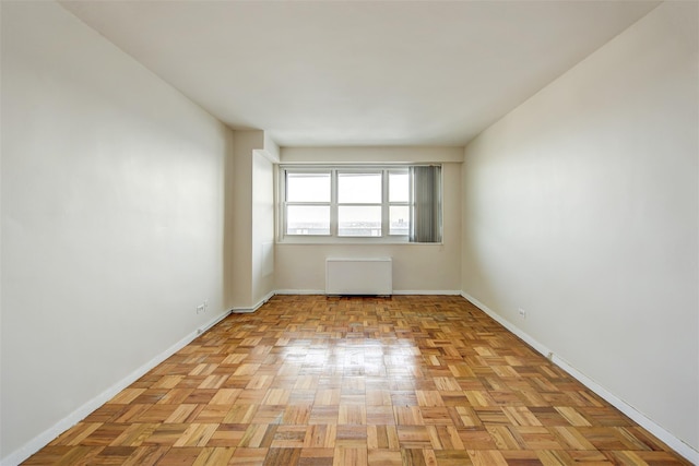 unfurnished room with light parquet flooring and radiator