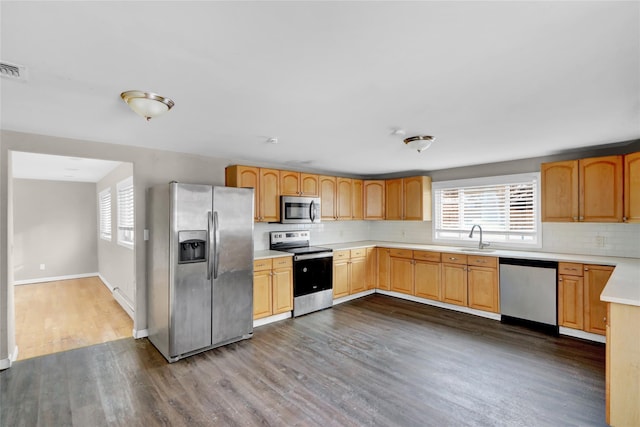 kitchen with dark wood-type flooring, sink, stainless steel appliances, and tasteful backsplash