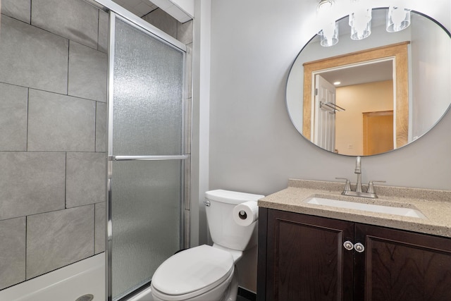 bathroom featuring toilet, walk in shower, and vanity