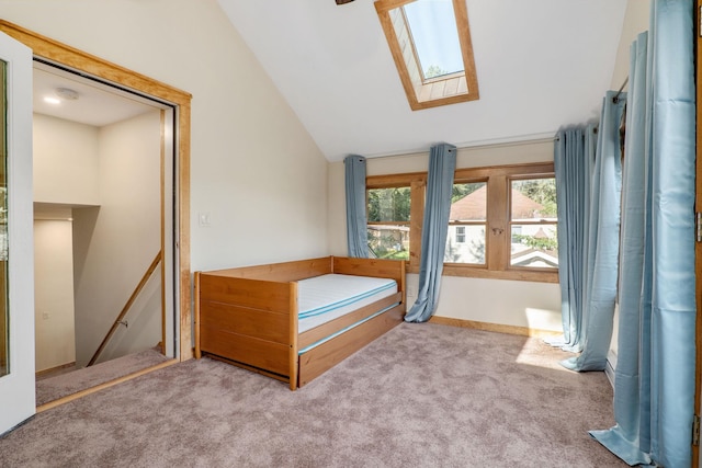 unfurnished bedroom featuring lofted ceiling with skylight and light carpet