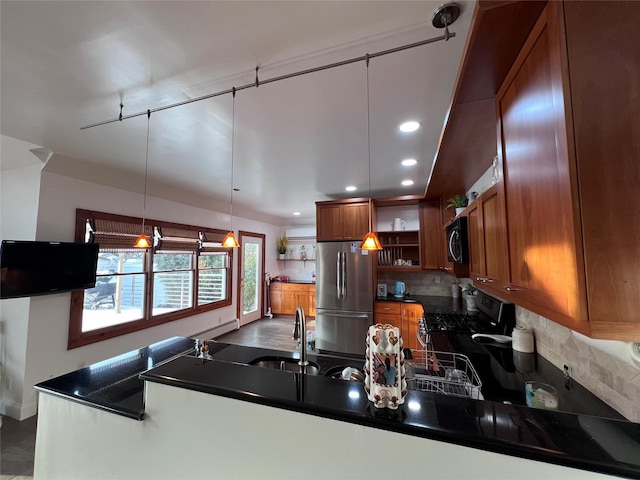 kitchen with tasteful backsplash, stainless steel appliances, decorative light fixtures, and sink