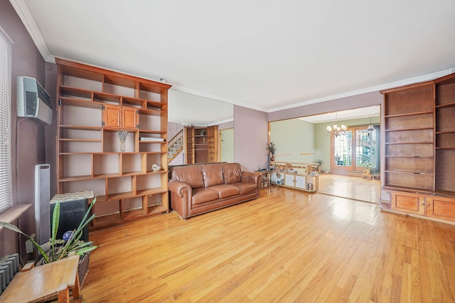 unfurnished living room with a wall mounted air conditioner, an inviting chandelier, crown molding, and light hardwood / wood-style flooring