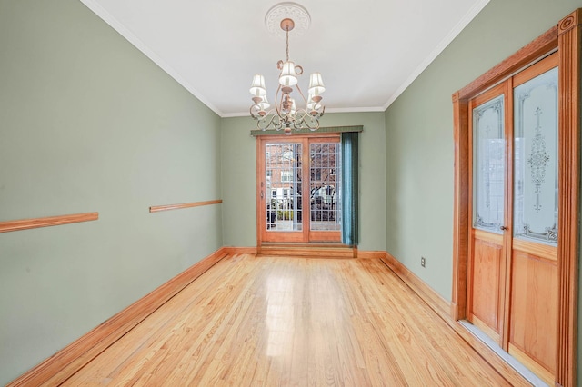 unfurnished dining area with ornamental molding, a chandelier, and hardwood / wood-style flooring