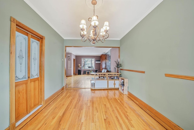 foyer entrance featuring ornamental molding, light hardwood / wood-style floors, and a chandelier