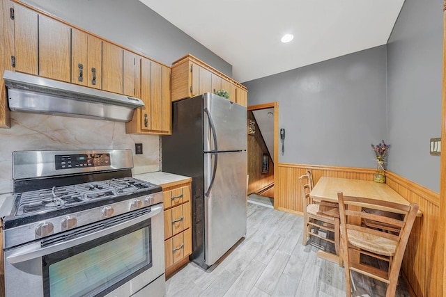 kitchen with light wood-type flooring, appliances with stainless steel finishes, and a baseboard radiator