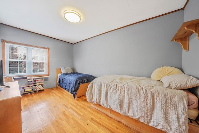 bedroom with ornamental molding and hardwood / wood-style flooring