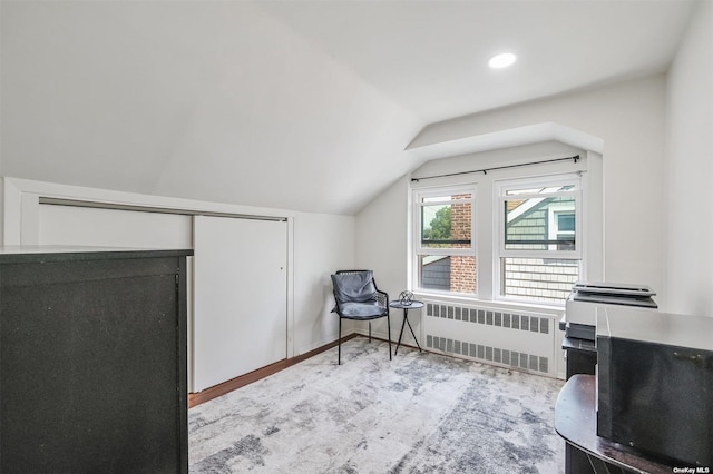 interior space featuring radiator heating unit and vaulted ceiling