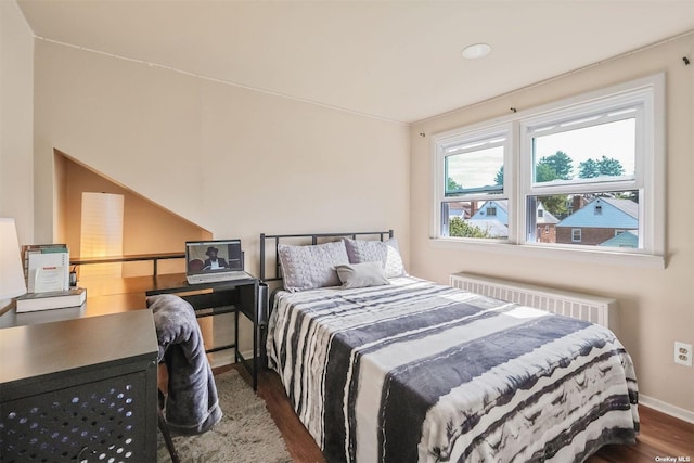 bedroom with radiator and dark wood-type flooring