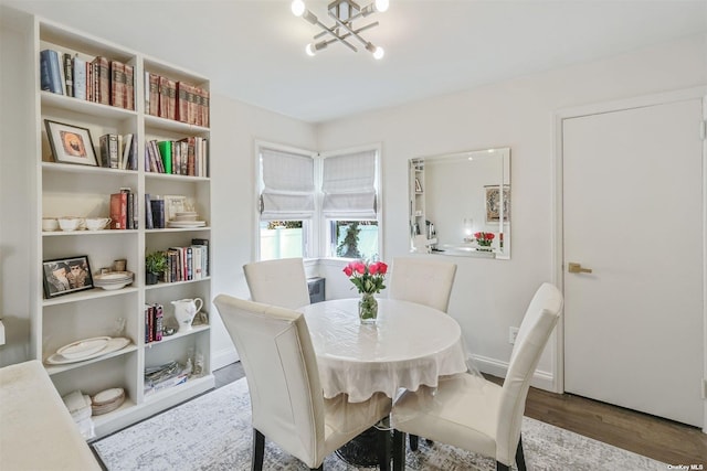 dining space with wood-type flooring and a notable chandelier