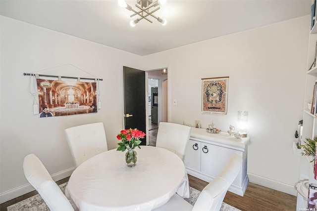 dining area with dark hardwood / wood-style floors and a notable chandelier