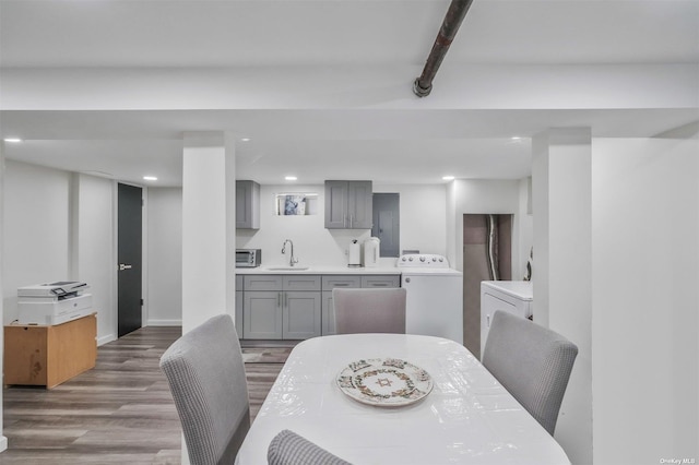 dining area with sink, wood-type flooring, washer / dryer, and beam ceiling