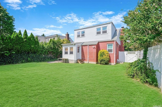 rear view of house featuring a lawn