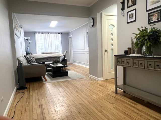 living room featuring crown molding and light hardwood / wood-style flooring