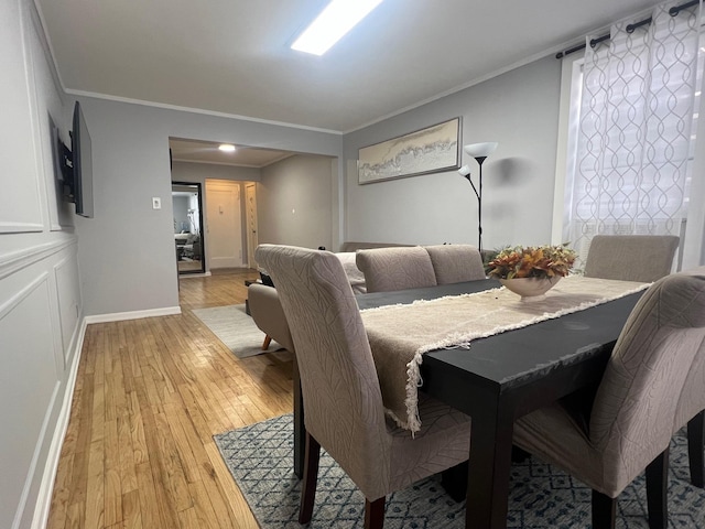 dining area featuring light hardwood / wood-style floors and ornamental molding