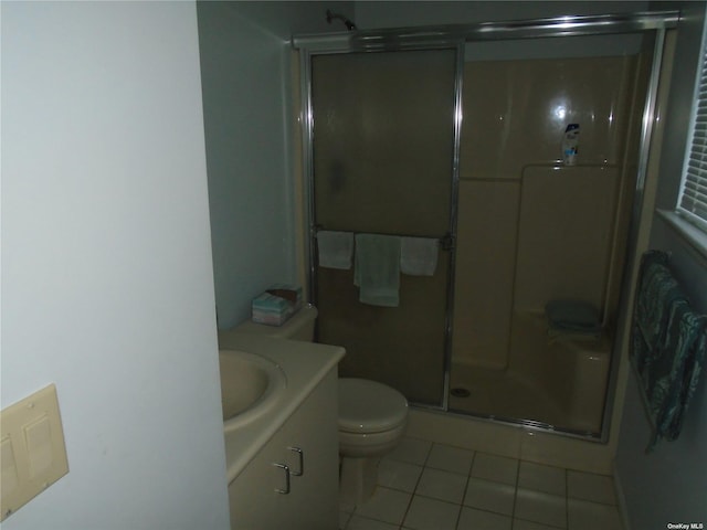 bathroom with toilet, walk in shower, vanity, and tile patterned flooring