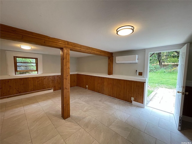 basement with wooden walls, an AC wall unit, and a baseboard radiator