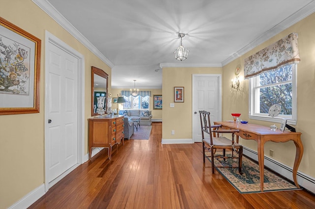 dining area featuring crown molding, a wealth of natural light, hardwood / wood-style floors, and a notable chandelier