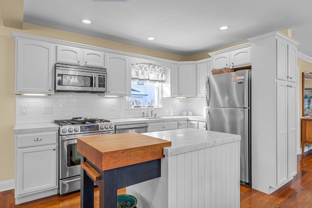 kitchen with sink, white cabinetry, tasteful backsplash, light wood-type flooring, and stainless steel appliances