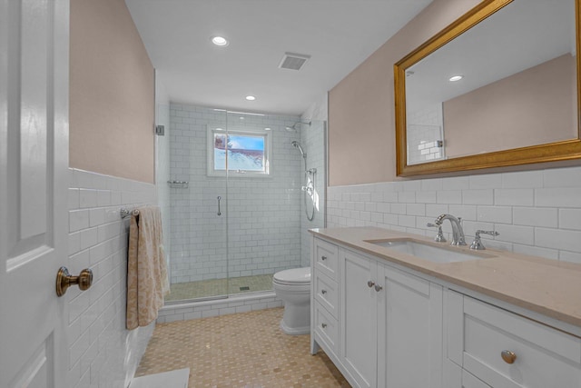 bathroom featuring vanity, an enclosed shower, tile patterned flooring, and tile walls