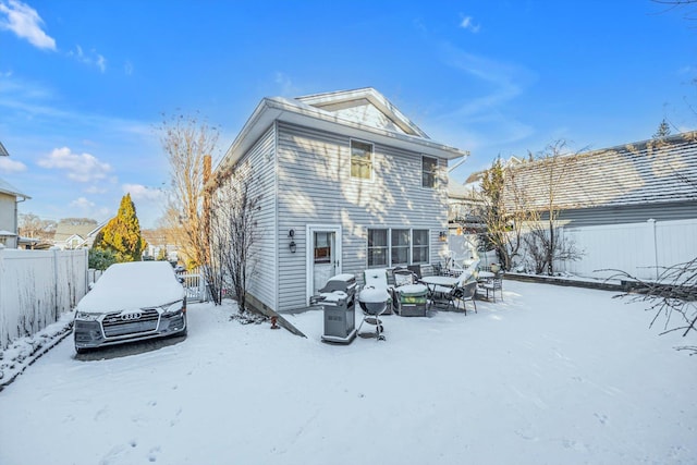 view of snow covered rear of property