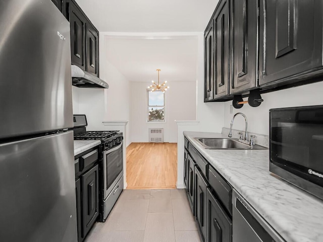 kitchen featuring decorative light fixtures, a notable chandelier, sink, radiator, and appliances with stainless steel finishes