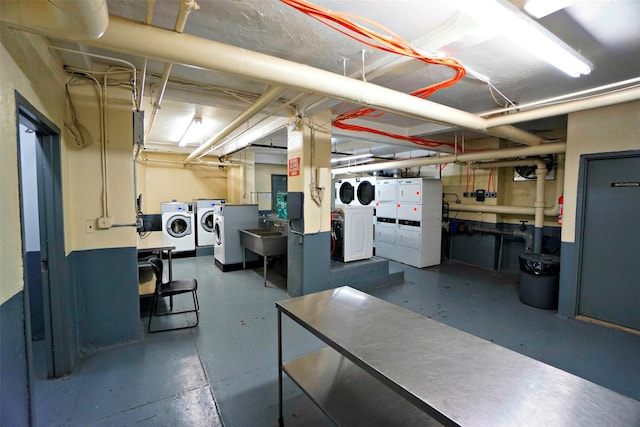 basement featuring washing machine and dryer, stacked washer and clothes dryer, and sink