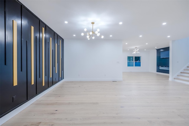 unfurnished room featuring an inviting chandelier and light hardwood / wood-style floors