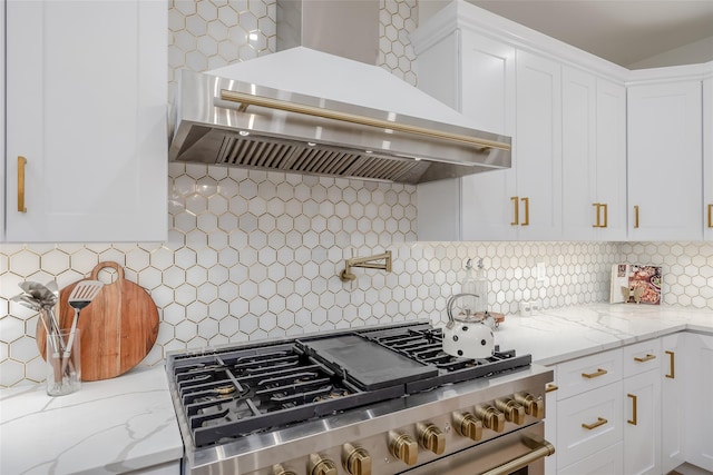 kitchen featuring white cabinetry, decorative backsplash, premium range hood, stainless steel stove, and light stone counters