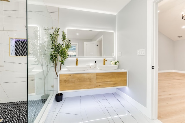 bathroom with vanity, a tile shower, and tile patterned flooring