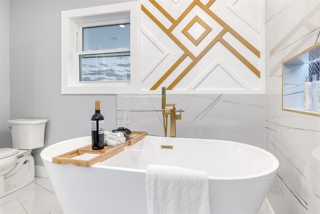 bathroom with toilet, a bathing tub, and plenty of natural light