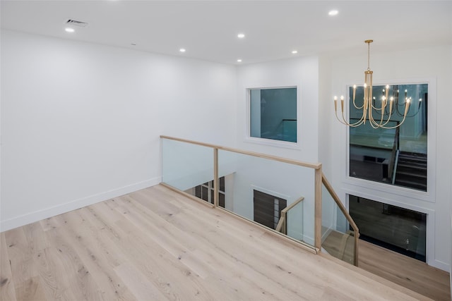 interior space featuring light wood-type flooring and an inviting chandelier