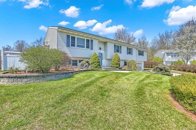 bi-level home with a front yard and a garage