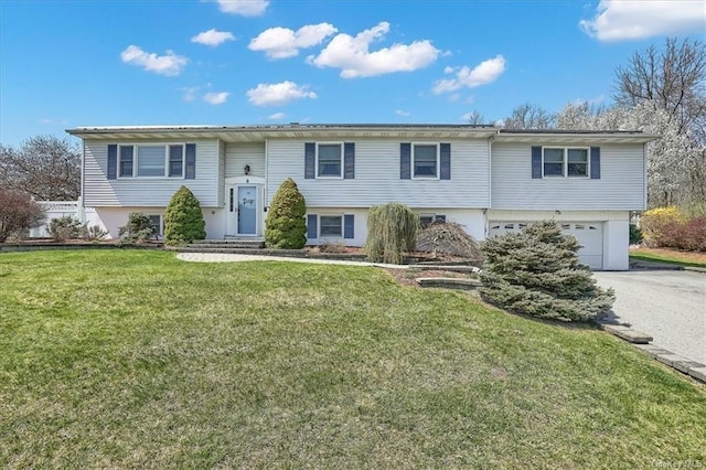 split foyer home featuring a garage and a front yard