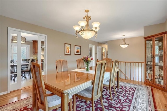 dining space with a chandelier and light hardwood / wood-style floors